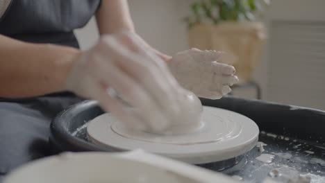 Close-up-of-the-hand-of-a-master-working-on-a-potter's-wheel-for-the-manufacture-of-clay-and-ceramic-jugs-and-plates-in-slow-motion